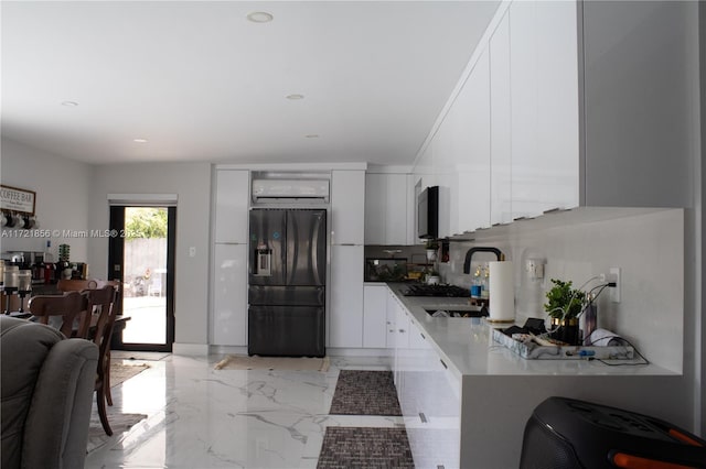 kitchen with white cabinets, black fridge, and sink