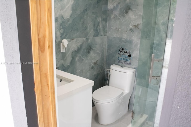 bathroom with vanity, tile walls, and toilet