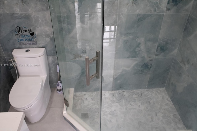 bathroom with tiled shower and toilet