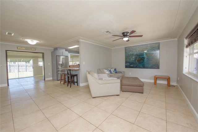 living room featuring ceiling fan, ornamental molding, and light tile patterned flooring