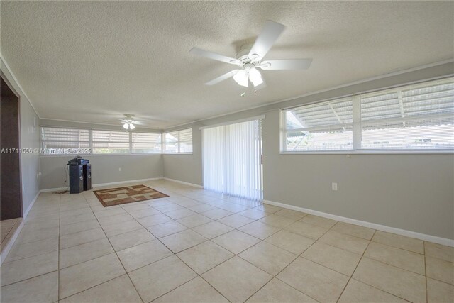 interior space with light tile patterned floors, a textured ceiling, ceiling fan, and crown molding