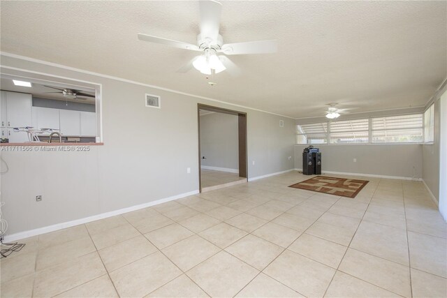 unfurnished room featuring light tile patterned floors, a textured ceiling, ceiling fan, and crown molding