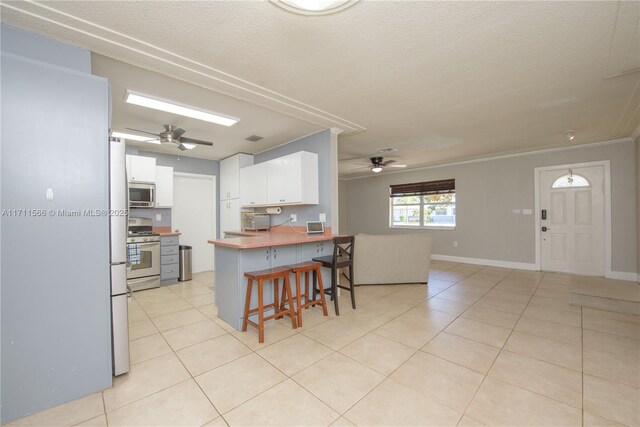 living area with ceiling fan, light tile patterned floors, and crown molding