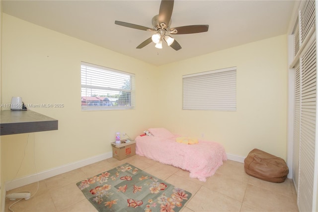 bedroom featuring light tile patterned floors, a closet, and ceiling fan