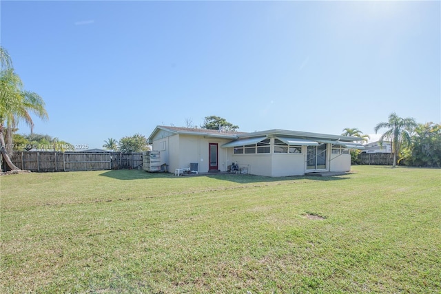 rear view of house featuring a yard