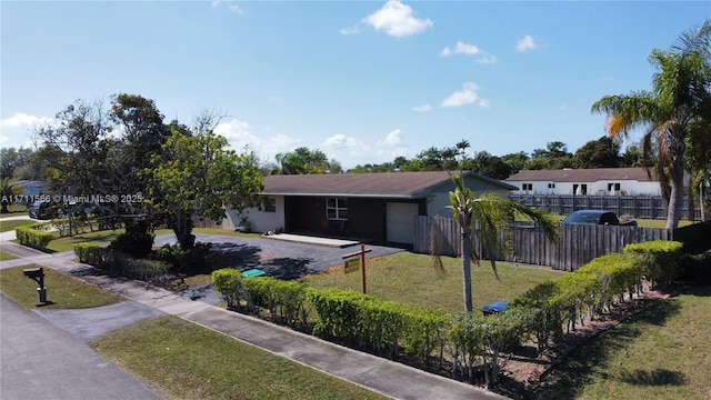 single story home featuring a garage and a front yard