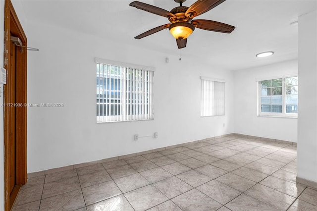 tiled empty room featuring ceiling fan