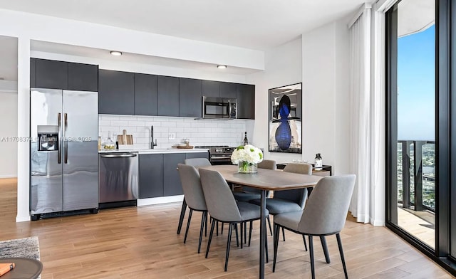 dining area featuring sink and light wood-type flooring