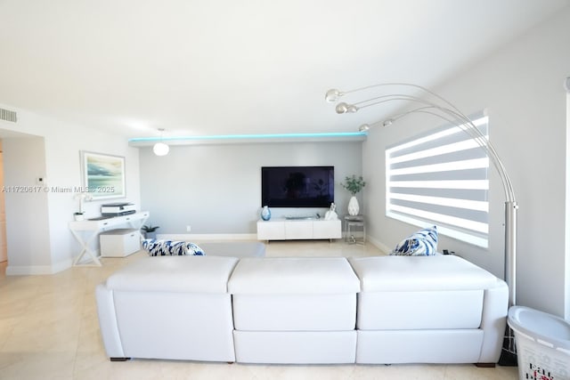 living area featuring light tile patterned floors, baseboards, and visible vents