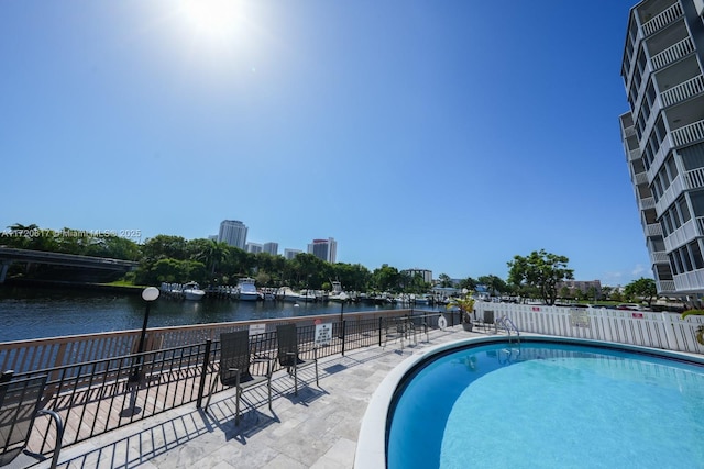 pool with a water view, a city view, and fence