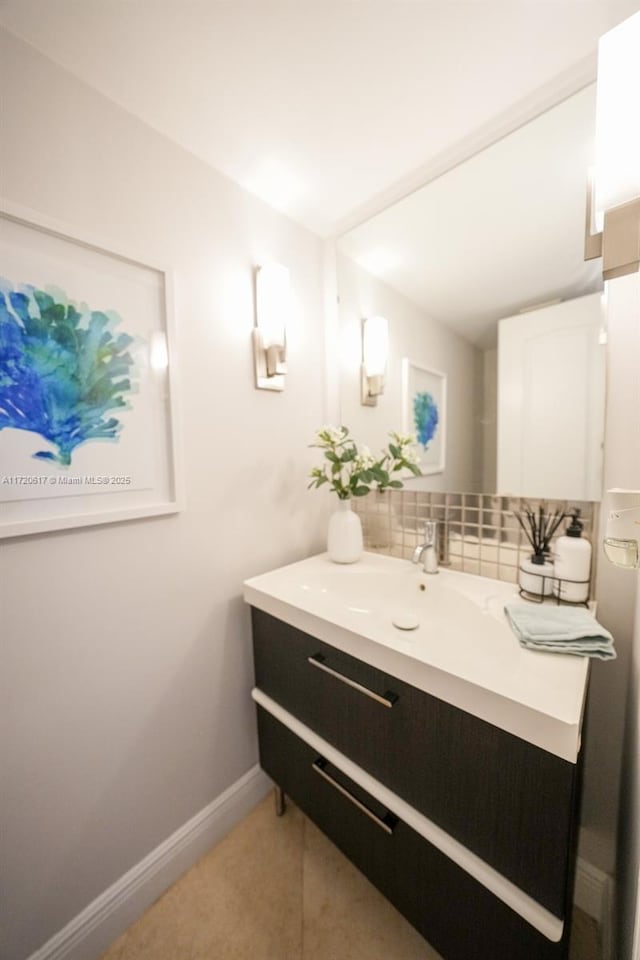 bathroom featuring decorative backsplash, vanity, and baseboards