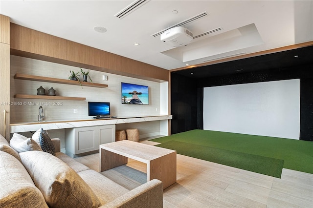 game room featuring golf simulator, sink, and a tray ceiling