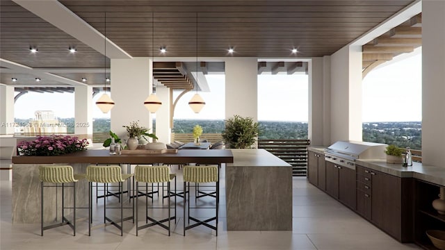 exterior space with a kitchen breakfast bar, dark brown cabinetry, a kitchen island, and pendant lighting