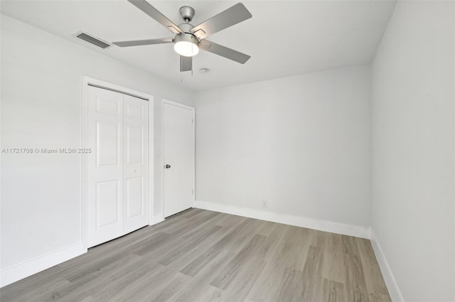 unfurnished bedroom featuring ceiling fan, a closet, and light hardwood / wood-style floors