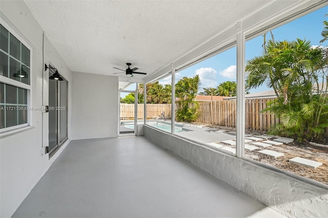 unfurnished sunroom with ceiling fan