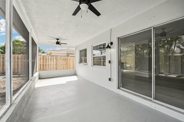 unfurnished sunroom featuring ceiling fan