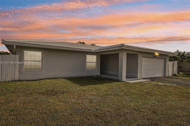 property exterior at dusk with a yard and a garage