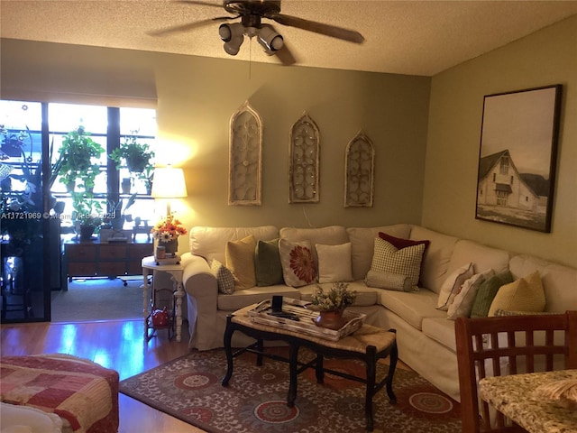 living room featuring hardwood / wood-style floors, a textured ceiling, and ceiling fan