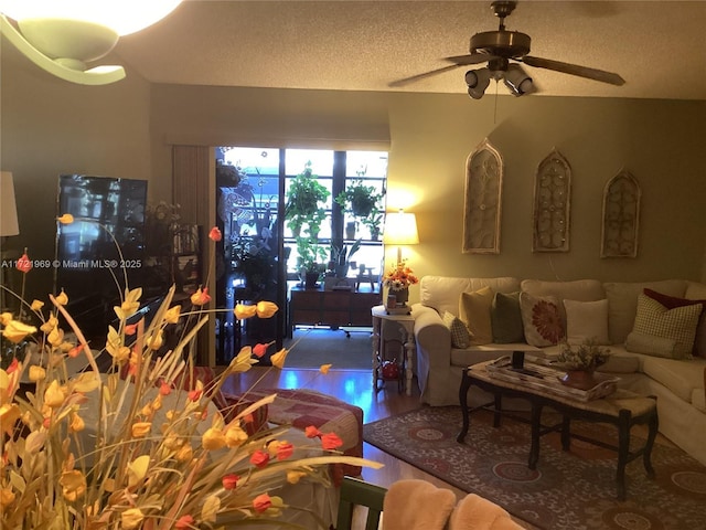 living room with ceiling fan, a textured ceiling, and hardwood / wood-style flooring