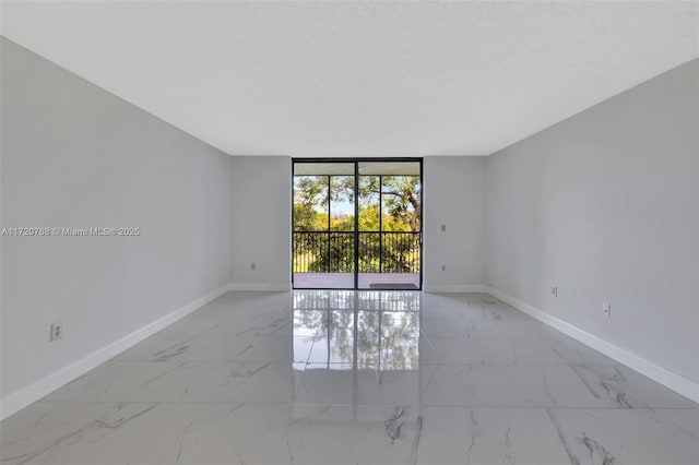 empty room featuring a wall of windows