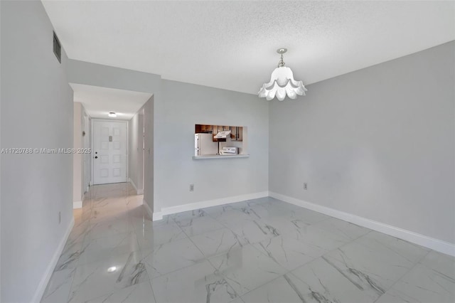 spare room with a textured ceiling