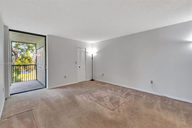 carpeted empty room with a textured ceiling