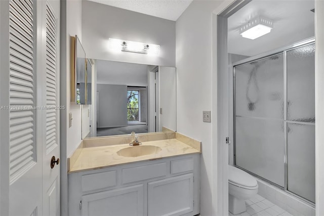 bathroom with tile patterned flooring, vanity, an enclosed shower, and toilet