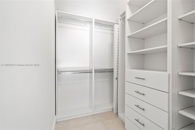 walk in closet with light tile patterned floors