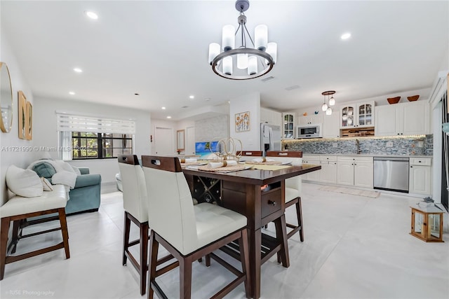 dining space with an inviting chandelier and sink