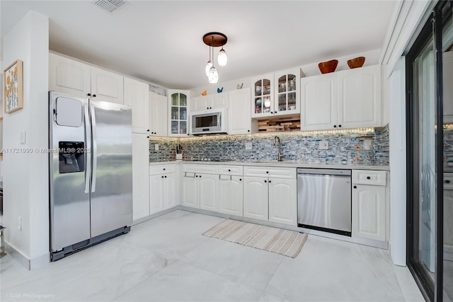 kitchen with tasteful backsplash, white cabinetry, sink, and appliances with stainless steel finishes