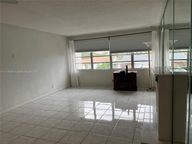 tiled spare room featuring a textured ceiling