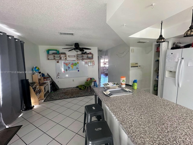 10331 SW 135th Ct, Miami, FL 33186 - kitchen featuring ceiling fan, a kitchen breakfast bar, a textured ceiling, and white refrigerator with ice dispenser