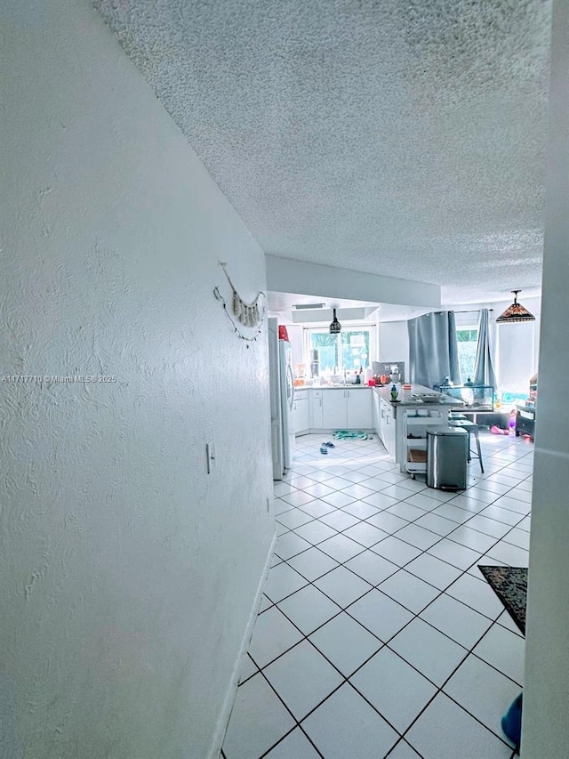 10331 SW 135th Ct, Miami, FL 33186 - unfurnished living room with a healthy amount of sunlight, a textured ceiling, and light tile patterned flooring