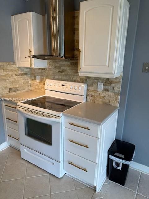 3426 Theo Way Unit 3426, West Palm Beach, FL 33417 - kitchen with white range with electric cooktop, wall chimney exhaust hood, light tile patterned floors, light countertops, and white cabinetry
