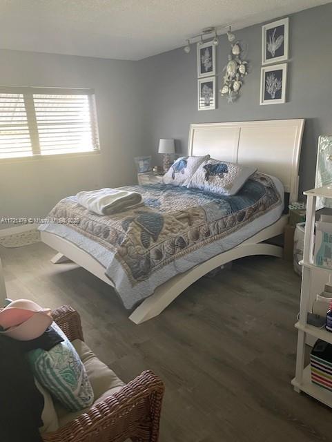 bedroom with dark hardwood / wood-style floors