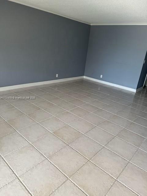3426 Theo Way Unit 3426, West Palm Beach, FL 33417 - tiled spare room with crown molding, baseboards, and a textured ceiling