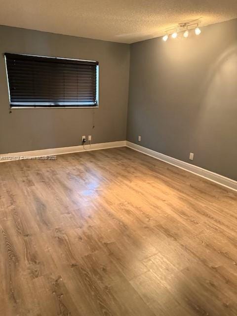 3426 Theo Way Unit 3426, West Palm Beach, FL 33417 - spare room featuring wood finished floors, a textured ceiling, and baseboards