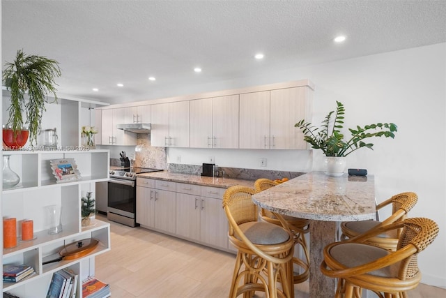 kitchen featuring kitchen peninsula, light stone countertops, backsplash, a textured ceiling, and stainless steel electric stove