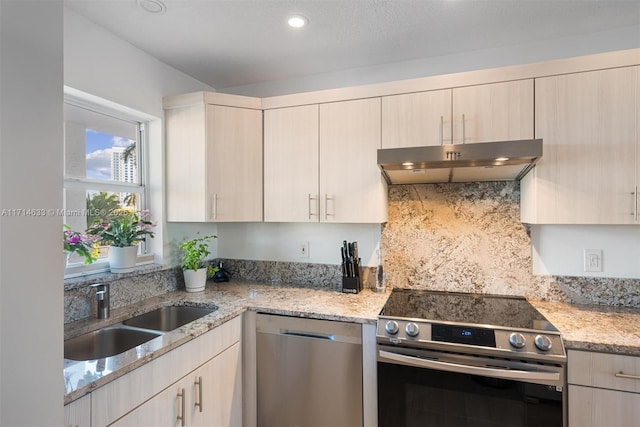 kitchen featuring light stone counters, light brown cabinetry, sink, and appliances with stainless steel finishes