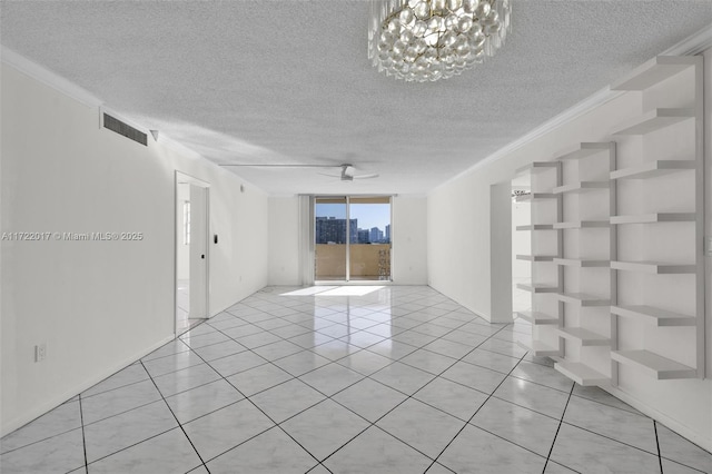 tiled empty room with ceiling fan with notable chandelier, ornamental molding, and a textured ceiling