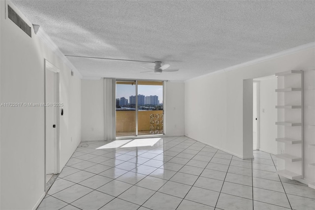 spare room with expansive windows, ornamental molding, a textured ceiling, ceiling fan, and light tile patterned floors