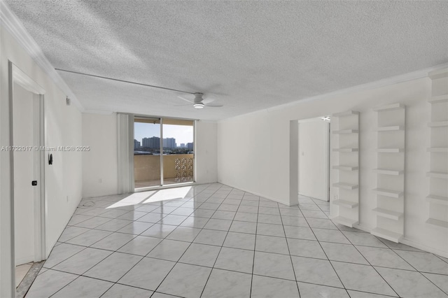 empty room with a textured ceiling, ceiling fan, crown molding, and light tile patterned flooring