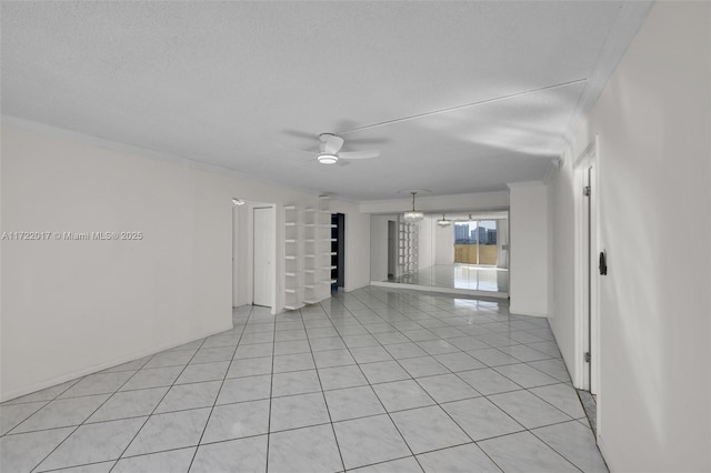 tiled empty room featuring a textured ceiling, ceiling fan, and crown molding