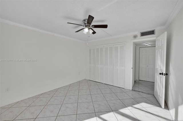 tiled empty room featuring a textured ceiling, ceiling fan, and ornamental molding