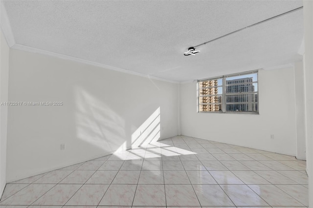 spare room with crown molding, light tile patterned floors, and a textured ceiling