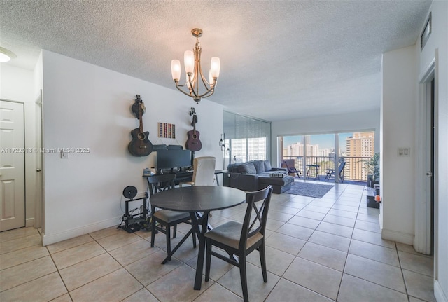 tiled dining area featuring a textured ceiling and a chandelier