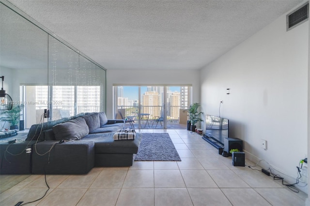 tiled living room featuring a textured ceiling