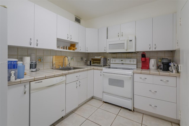 kitchen featuring white cabinetry, tile counters, sink, backsplash, and white appliances