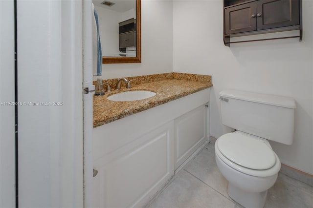 bathroom with tile patterned flooring, vanity, and toilet