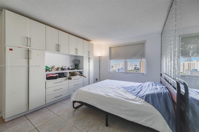 tiled bedroom with a textured ceiling and multiple windows